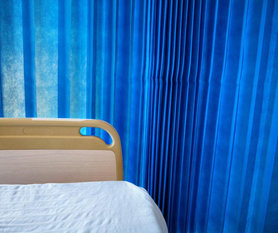 hospital bed in front of blue curtain