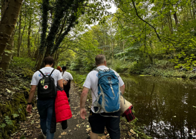 An image showing three people walking along a canal - there are lots of trees!