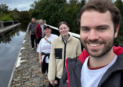 A group of people stand in a line along a canal
