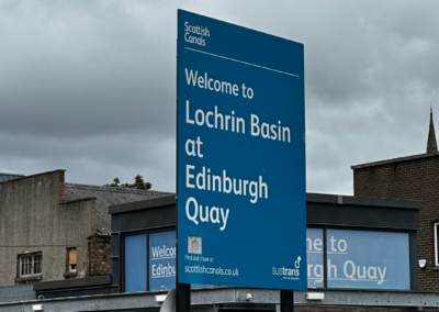 A photo of a blue Scottish Canal sign which reads 'Welcome to Lochrin Basin at Edinburgh Quay'