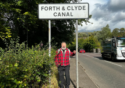 A man (Greg) stands under a sign which reads 'Forth & Clyde Canal'