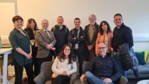 A group of people posing for a picture and smiling in a modern office environment. | Carr Gomm