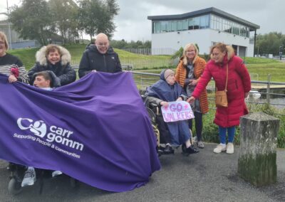 A group photo of seven people holding a big purple Carr Gomm banner and a sign saying 'Go Walkers!'