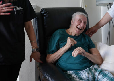 An older man sitting in a recliner chair and smiling. Carr Gomm