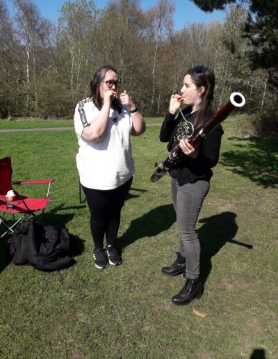 Craigmillar Community Grows: Two women are standing in a grass area, one is playing the bassoon