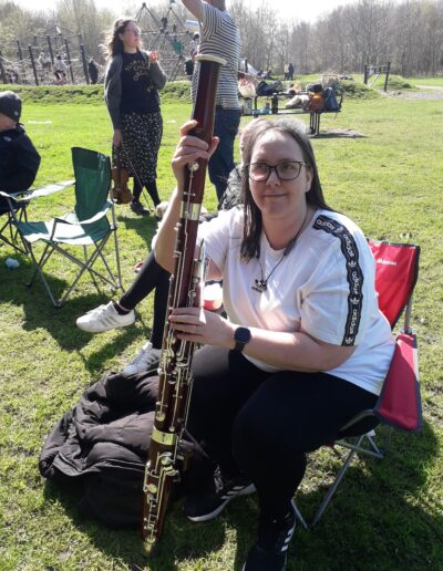 Craigmillar Community Grows: A women sits smiling at the camera holding a bassoon