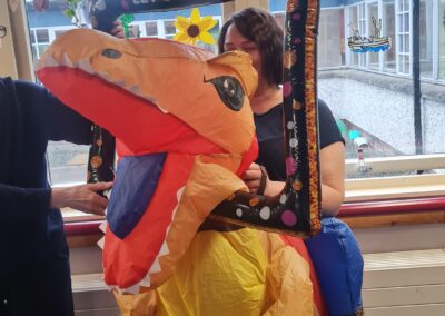A women is dressed in an inflatable dinosaur costume