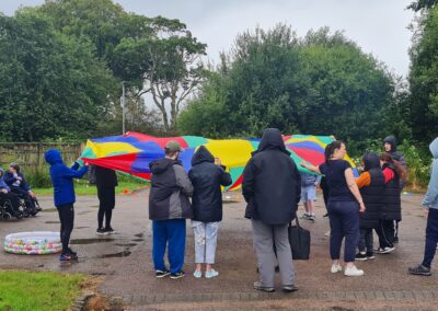 A group of people play parachute games in the rain.