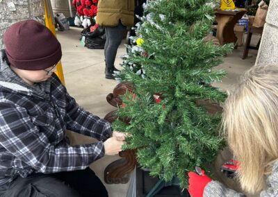 Two people decorating a Christmas tree.