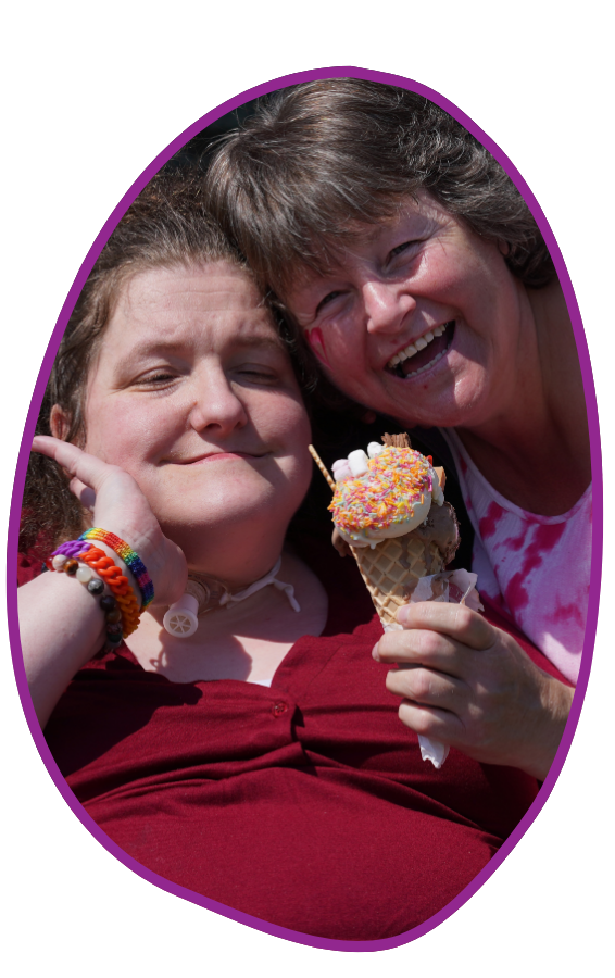 Glasgow Two women are smiling at the camera. One is holding an ice cream cone.