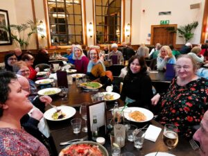 A group of people are in a restaurant. They are smiling at the camera.