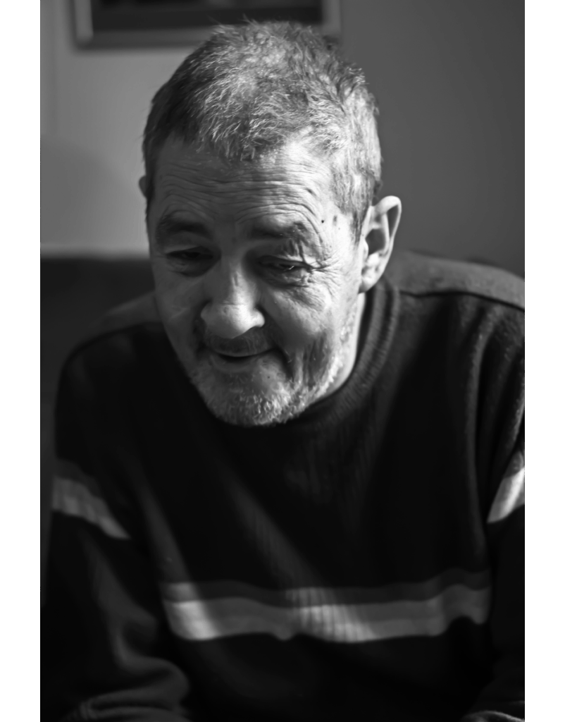 a black and white photo of a man sitting in a chair. | Carr Gomm