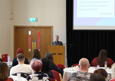 Person presents to a group of people from behind a lectern.