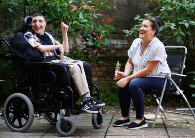 a person in a wheelchair with a person sitting next to them
