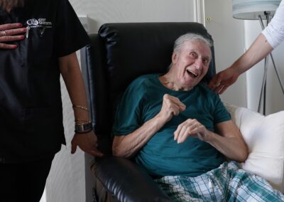 a man sitting in a chair with a support worker wearing a tunic uniform. | Carr Gomm Highland