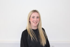 Person standing against white background smiling