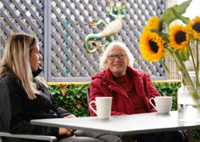 Two people enjoying a conversation over coffee at a table adorned with sunflowers