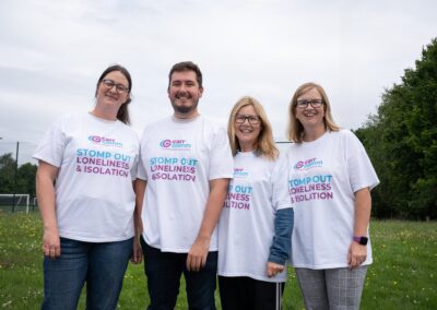 Four people standing outsiding and smiling wearing Carr Gomm branded tshirts