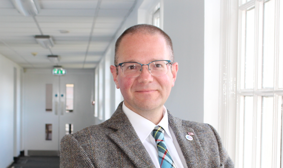 Portrait of man in suit with glasses.