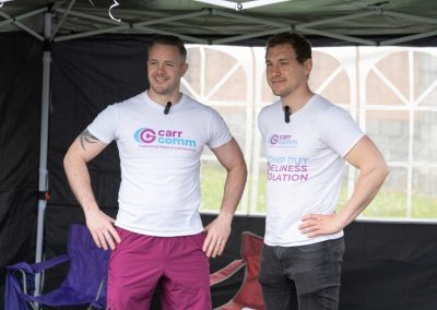 Forth Valley Sports Day organisers Vadim and Danial - Two men in white Carr Gomm shirts stand with their hands on their hips.
