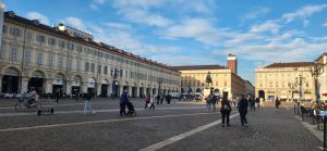 A historic town square with people walking through it