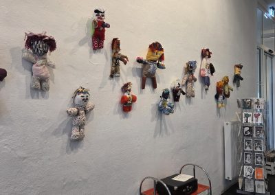 Soft toy art work on a white wall.