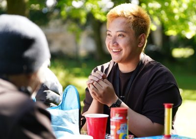 A young man sitting at a picnic table smiling