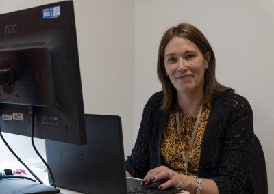 Susan Colin (Service Manager) sitting at a computer