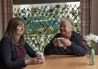 A young woman and an older woman sitting in a cafe having a chat.
