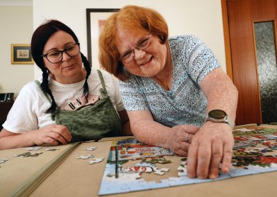 Two women (Diane and Anne) work on a jigsaw in living room environment.