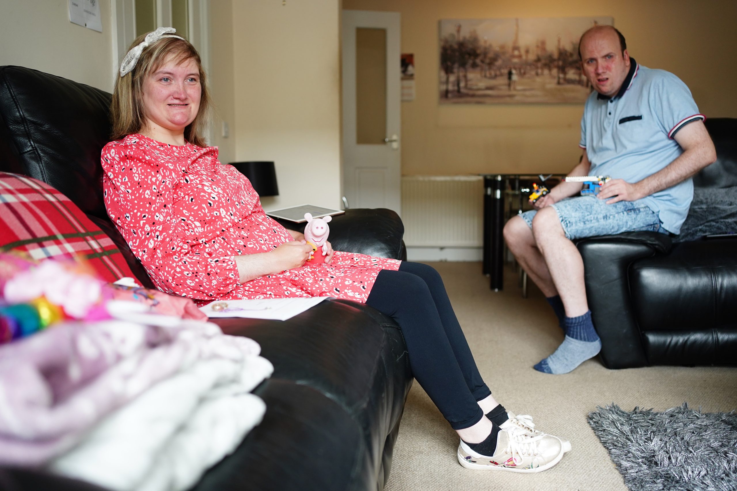 A young woman (Yvonne) and a young man (Simon) sit on sofa in living room setting. | Carr Gomm Learning Disabilities