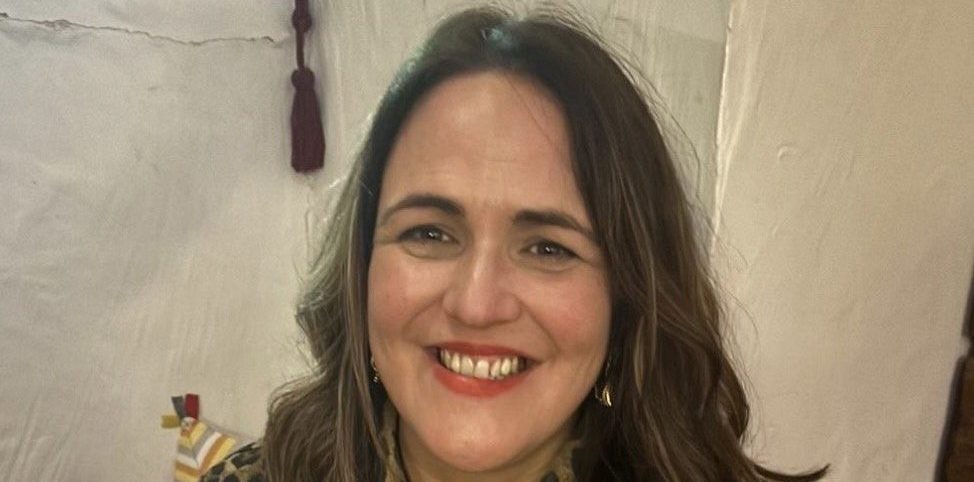 Woman with brown hair smiling at camera.