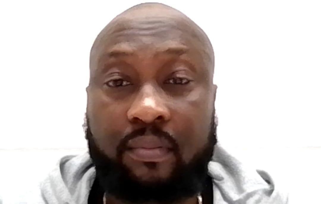 Man with beard wearing a hoodie facing camera.