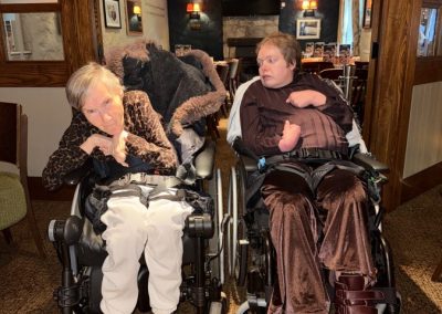 Two women, Gillian and Ailsa, sitting in their wheelchairs at the entrance to a restaurant