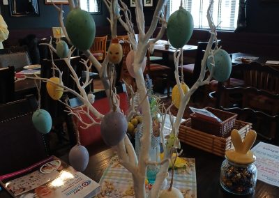 A decorative tree with pastel painted eggs hanging from the branches