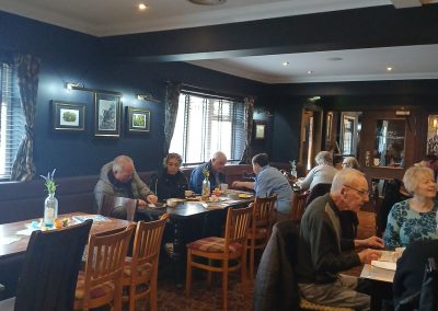 A restaurant full of people sitting at tables.