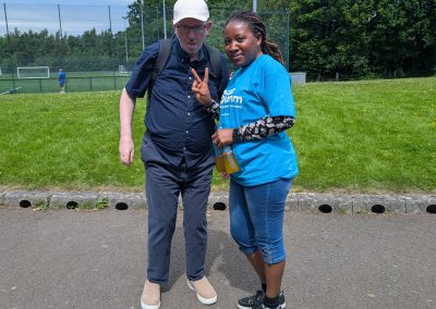A man and woman pose for a picture in a sports field.