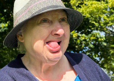 A woman is sitting in the sun wearing a grey hat