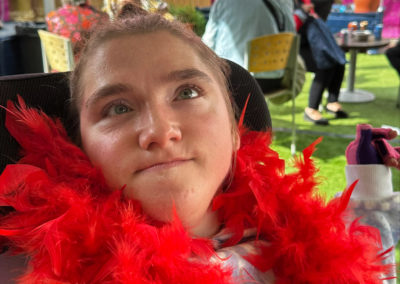 A women in a red boa stares at the camera